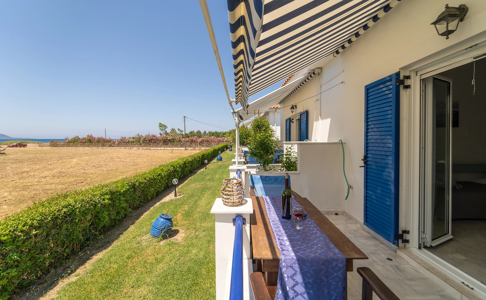 A table set on a private veranda at Blue Houses looking out over the sea and garden