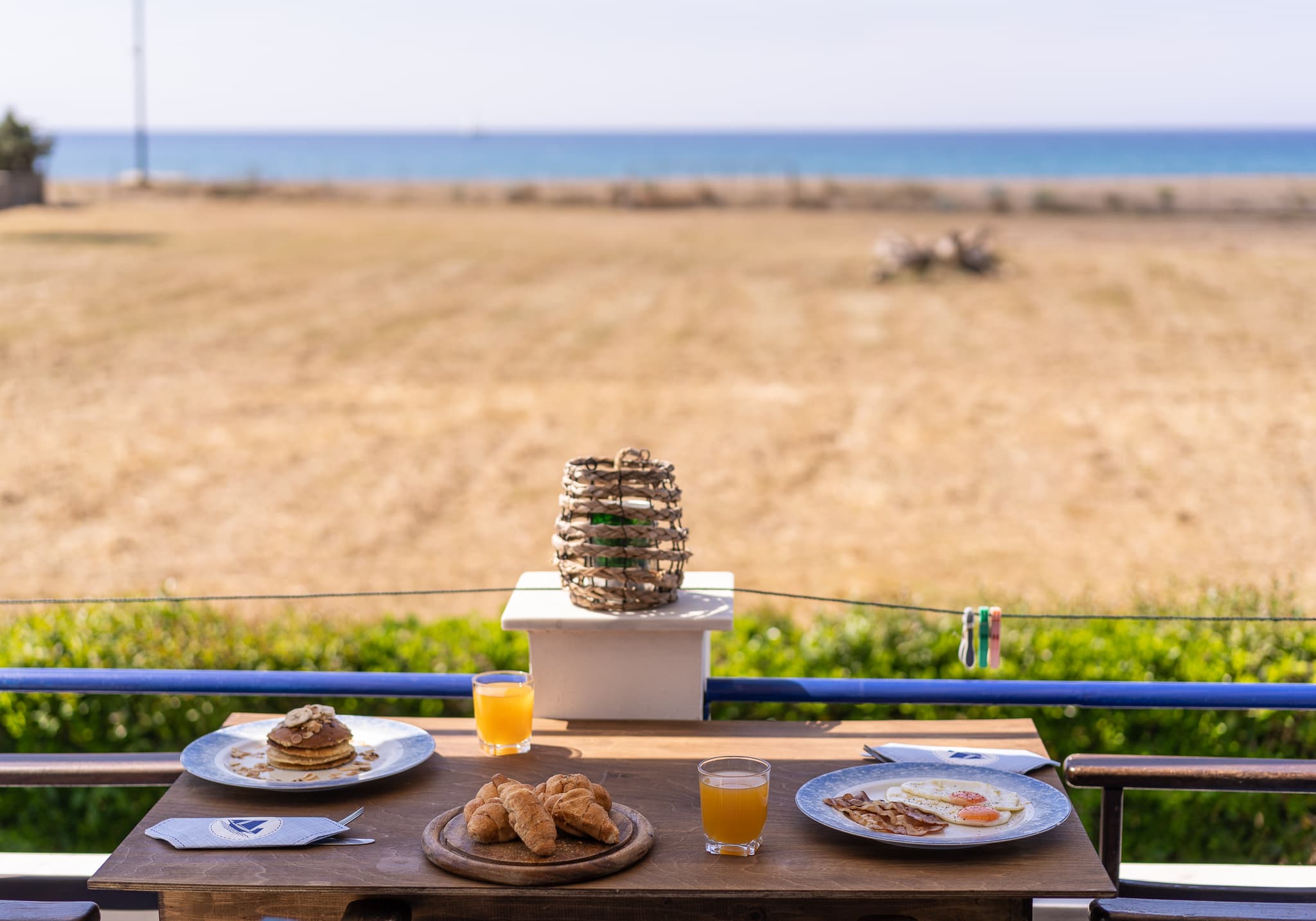 Breakfast laid out on a balcony table overlooking the sea at Blue Houses