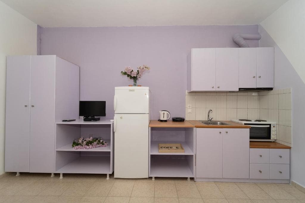 A fully equipped kitchen with fridge, hob, microwave and storage in a Blue Houses maisonette