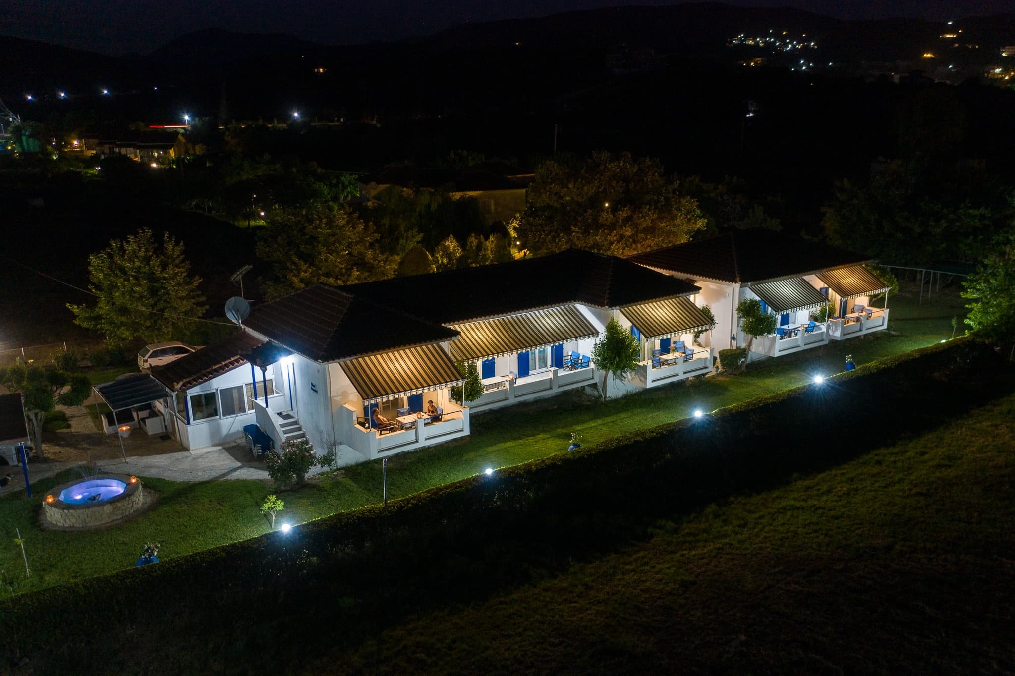 Blue Houses at night, lit up among the trees in Finikounda